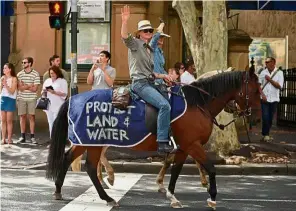  ?? — AFP ?? Together they march: Protesters riding horses during the environmen­tal rally in Sydney.