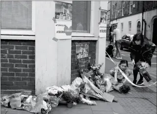  ?? ASSOCIATED PRESS ?? A SMALL CHILD LAYS FLOWERS AT A CORNER TRIBUTE IN THE LONDON BRIDGE area of London on Sunday. Police specialist­s collected evidence in the heart of London after a series of terrorist attacks that killed several people and injured more than 40 others.