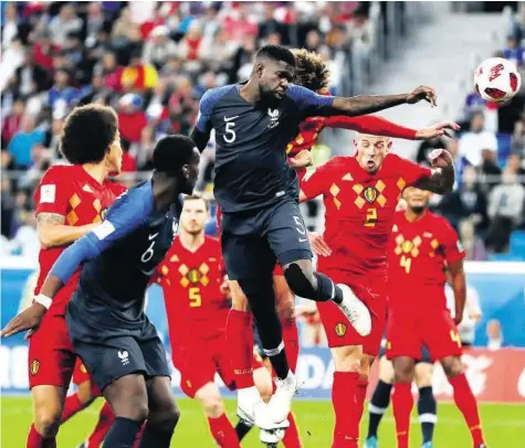  ?? AP ?? Samuel Umtiti (M.) gewinnt das Kopfball-Duell gegen Belgiens Marouane Fellaini und trifft zum 1:0.