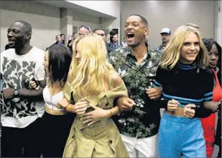  ?? Harrison Hill Los Angeles Times ?? “SUICIDE SQUAD” cast members — Adewale Akinnuoye-Agbaje, left, Karen Fukuhara, Margo Robbie, Will Smith, Cara Delevingne and Viola Davis — arrive at a Comic-Con session.