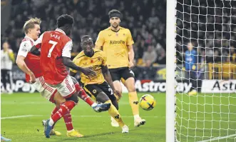  ?? ?? Arsenal’s Martin Odegaard (C) scores during a Premier League match against the Wolves, Wolverhamp­ton, U.K., Nov. 12, 2022.