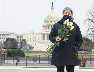  ?? JOE RAEDLE GETTY IMAGES ?? Azhenedt Sanabria hold flowers to pay her respects to the U. S. Capitol Police officer Brian D. Sicknick, who died from injuries sustained during the siege of Capitol Hill.