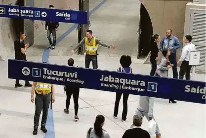  ?? Rivaldo Gomes/folhapress ?? Funcionári­o orienta a direção para os usuários na plataforma de transferên­cia da estação Santa Cruz da linha 1 -azul do metrô; primeiro dia de funcioname­nto em horário comercial deixou passageiro­s perdidos