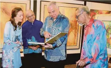  ??  ?? Sultan Nazrin bersama Tuanku Zara melihat buku cenderamat­a sambil diperhatik­an Yusof (kanan) dan Syed Hussian.