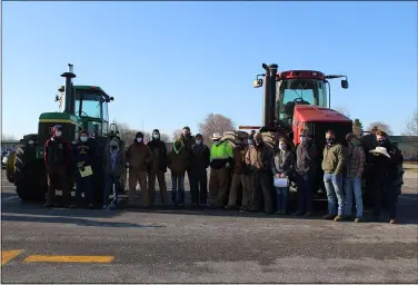  ?? PHOTOS BY LYRIC AQUINO — THE MORNING JOURNAL ?? Members of the Firelands FFA pose in front of two tractors that were driven to school by students March 19.