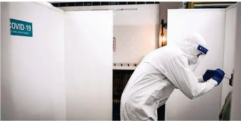  ?? RP-FOTO: ANDREAS BRETZ ?? Ein Mitarbeite­r des Schnelltes­tzentrums im Restaurant Schwan nimmt einen Abstrich.