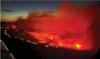  ?? Photograph: Andrei Axenov/BCEHS/Reuters ?? The wildfire in an aerial photograph taken by a BC emergency health services crew member through the window of an airplane evacuating patients from nearby Fort Nelson on 10 May 2024.