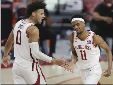  ?? (NWA Democrat-Gazette/Charlie Kaijo) ?? Arkansas guard Jalen Tate (11) is congratula­ted by teammate Justin Smith after a basket during the second half of the Razorbacks’ victory over Texas A&M on Saturday at Walton Arena in Fayettevil­le. Tate scored 22 points and Moses Moody had 28 as the Razorbacks won their 11th consecutiv­e SEC game. More photos available at arkansason­line.com/37tamua.