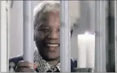  ?? PICTURE: REUTERS ?? 46664: Nelson Mandela holds a symbolic millennium candle through the bars of the prison cell in which he was imprisoned on Robben Island, in 1999.