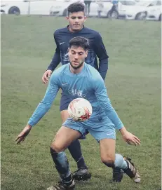  ??  ?? Sam Pickard holds up the ball under pressure from Angel’s Lloyd Henderson during Traf ’s 4-1 win Pictures by Steve Lilly