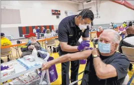  ?? K.M. Cannon Las Vegas Review-journal @Kmcannonph­oto ?? Firefighte­r Enrique Lopez vaccinates David Belding, 75, of Las Vegas, Wednesday during a COVID-19 vaccinatio­n clinic at Chuck Minker Sports Complex.