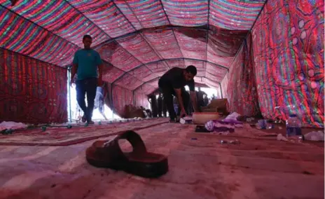  ?? SABAH ARAR/AFP/GETTY IMAGES ?? Iraqis clean a tent at the site of a suicide bombing Saturday. Iraq has had a rash of recent bombings, including one that killed 300 people in July.