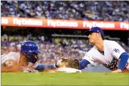  ?? MARK J. TERRILL ?? Los Angeles Dodgers first baseman Cody Bellinger, dives to tag out Chicago Cubs' Jason Heyward during the fifth inning of Game 2 of baseball's National League Championsh­ip Series in Los Angeles, Sunday.