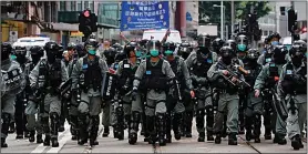  ??  ?? CLAMPDOWN: Riot police in Hong Kong march toward protesters