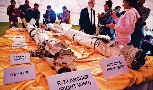  ?? Agence France-presse ?? ↑
Media personnel take photos of missiles of an Indian Mig-21 fighter aircraft, which was shot down over Kashmir, in Islamabad on Monday.