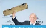  ??  ?? MUNICH: Israeli Prime Minister Benjamin Netanyahu holds up what he claims is a piece of an Iranian drone shot down in Israeli airspace as he gives a speech during the Munich Security Conference yesterday. — AFP