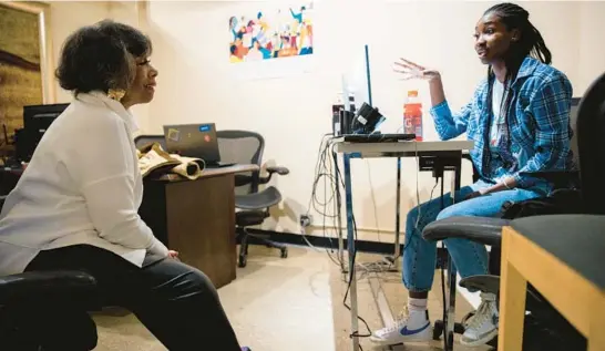  ?? VINCENT ALBAN/CHICAGO TRIBUNE PHOTOS ?? Hermene Hartman, left, speaks with Precious Adediran, a mentee, Feb. 9 at the N’DIGO office in Chicago.