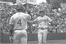  ?? AARON E. MARTINEZ/AMERICAN-STATESMAN ?? Texas shortstop Jalin Flores, right, crosses home after a home run against Washington at UFCU Disch–Falk Field in March. Flores hit two homers in Tuesday night’s 11-1 win over Abilene Christian.