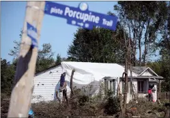  ?? CP PHOTO SEAN KILPATRICK ?? People tarp their damaged home Monday in Dunrobin, Ont. west of Ottawa, following a tornado that hit the area on Sept, 21.