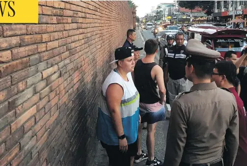  ?? CHIANG MAI NEWS VIA AP ?? Albertan Brittney Schneider, left, and Briton Furlong Lee, second from left, stand in front of Tha Pae Gate in Chiang Mai province, northern Bangkok.