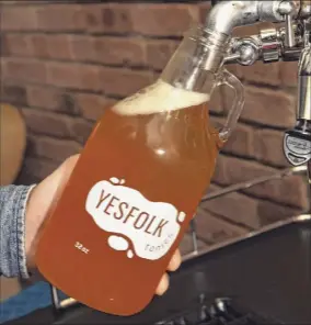  ?? Lori Van Buren / Times Union ?? Yesfolk Tonics co-founder Adam Elabd pours kombucha (fermented tea) from a tap at the former church in Troy where he makes the beverage.