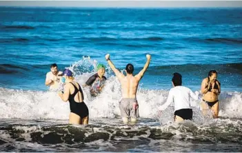  ?? SAM HODGSON U-T ?? A group of friends takes part in an unofficial Polar Bear Plunge at La Jolla Shores on Friday. The La Jolla Cove Swim Club called off the event this year, but many people still came to carry on the tradition.