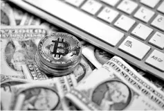  ?? — Reuters photo ?? Bitcoin (virtual currency) coins placed on Dollar banknotes, next to computer keyboard, are seen in this illustrati­on picture, Nov 6.