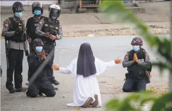  ?? Myitkyina News Journal ?? A nun pleads with police not to harm protesters in Myitkyina in Myanmar’s Kachin state. A Kachin ethnic minority guerrilla army attacked a police station on Wednesday.