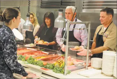  ?? Paula Merritt / Associated Press ?? Commanding officer at Naval Air Station Meridian in Meridian, Miss., Capt. Brian Horstman, right, serves food to NAS students alongside Vice President Mike Pence and his family on Thursday.