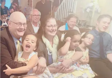  ?? COURTESY PHOTOS ?? Matthew Wesson, from left, holds daughter Amelia next to wife Marie Wesson, daughters Seraphina and Penelope, and son Dale after the three girls were formally adopted on Thursday in a ceremony in the family’s Manchester home.