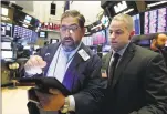  ?? Associated Press ?? Director of Trading Floor Operations Fernando Munoz, right, works with trader Robert Oswald, on the floor of the New York Stock Exchange on Wednesday.