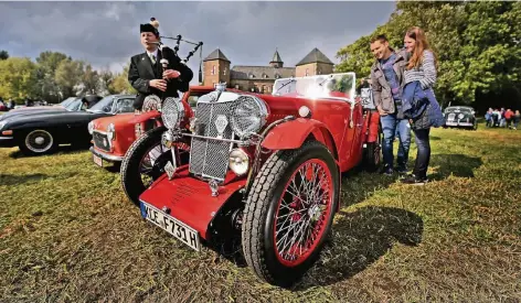  ?? RP-FOTO: MVO ?? Alle liebevoll restaurier­t: MG, Mini und Jaguar E-Type vor Burg Zelem, die Dudelsack-Spielerin spielte nicht nur zu Ehren von Bürgermeis­ter Steins.