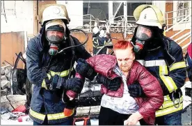  ?? ?? AIR STRIKE: Firefighte­rs help a resident after the missiles hit Odessa
