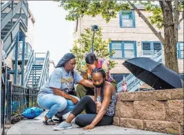  ?? Armando L. Sanchez The Associated Press ?? Jalisa Ford rubs the walkway where her 9-year-old son Janari Ricks was fatally shot while playing with friends at the Cabrini Green townhomes in Chicago.