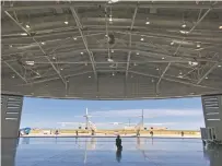  ?? SUSAN MONTOYA BRYAN/ASSOCIATED PRESS ?? Virgin Galactic ground crew guide the company’s carrier plane into a hangar at Spaceport America following a test flight Thursday.