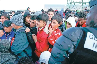  ?? PASCAL ROSSIGNOL / REUTERS ?? Migrants who claim to be minors wait for their registrati­on and their evacuation on the second day of the dismantlem­ent of the camp called the "Jungle" in Calais, France, on Tuesday.