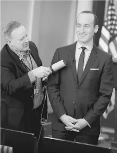  ??  ?? White House Press Secretary Sean Spicer removes lint from Miller’s jacket as he waits to go on the air in the White House Briefing Room in Washington, US. — Reuters photo