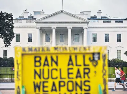  ??  ?? Das Weiße Haus am Tag der Einigung über das iranische Atomprogra­mm in Wien. Ein Demonstran­t erinnert daran, dass das Problem der Nuklearwaf­fen weiterhin besteht, auch wenn der Iran keine hat.
