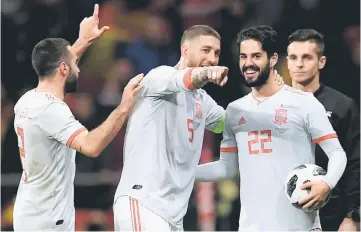  ??  ?? Spain’s Dani Carvajal, Sergio Ramos and midfielder Isco celebrate after a friendly against Argentina at the Wanda Metropolit­ano Stadium in Madrid. — AFP photo