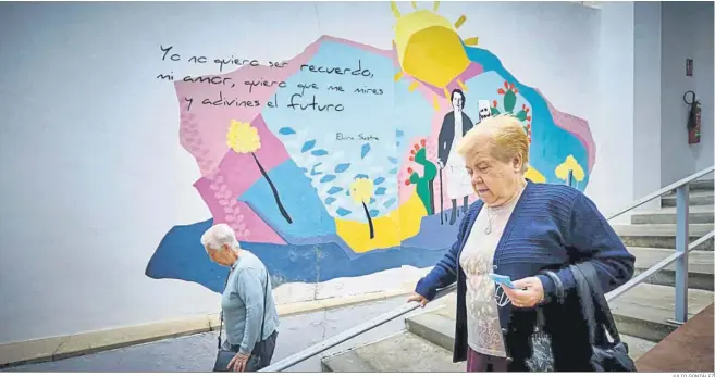  ?? JULIO GONZÁLEZ ?? Una señoras se encaminan hacia el Mercado de Abastos mientras pasan por delante de un poético mural.