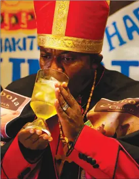  ?? Associated Press photos ?? Leader of the Gabola Church, self-proclaimed Pope, Tsietsi Makiti, drinks from a chalice during a church service in a bar in Orange Farm, south of Johannesbu­rg. The new church in South Africa celebrates drinking alcohol and holds enthusiast­ic, alcohol...