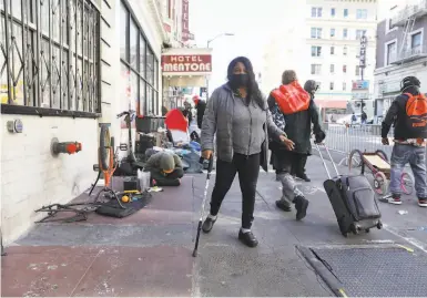  ?? Photos by Lea Suzuki / The Chronicle ?? “The Tenderloin always seems to be neglected,” says Cheryl Shanks, navigating Ellis Street.