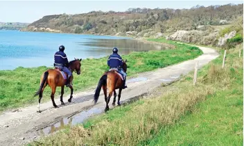  ?? — AFP ?? Garde républicai­ne mounted gendarme patrol a footpath close to La Ville-ès-Nonais in western France on Thursday, following a strict lockdown to stop the spread of Covid-19.