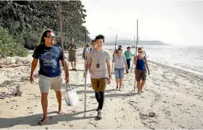  ?? Photo: FAIRFAX NZ ?? Linc Walker, left, leads a group along Cooya Beach during a Kuku Yalanji Cultural Habitat Tour.