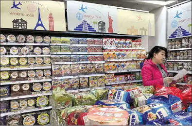  ?? AP/NG HAN GUAN ?? A vendor stocks imported food at a mall in Beijing in March. Chinese regulators are being asked to suspend a proposed requiremen­t that each food shipment to China carry an inspection certificat­e from the nation of origin.