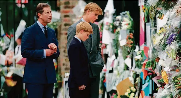  ?? PHOTO: ANWAR HUSSEIN ?? Prince William and Prince Harry look at floral tributes to Diana, Princess of Wales outside Kensington Palace on September 5, 1997 in London, England.