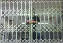  ?? [AFP·연합뉴스] ?? 지난 4일 중국 베이징의 한 지하철역에서 한 남성이 철제 게이트를 자물쇠로 잠그고 있다. 베이징당국은이날 코로나19 확산을 막기위해베이징시내지­하철역40여개를임시­폐쇄했다.