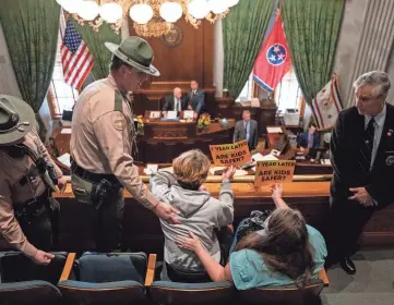  ?? SETH HERALD/REUTERS ?? Tennessee state troopers ask gun-reform activists to clear the Senate Gallery after Lt. Gov. Randy McNally, R-Oak Ridge, ordered the gallery cleared in Nashville on Tuesday. Gun-reform activists gathered to protest SB1325, which would authorize teachers, principals and school personnel to carry a concealed handgun on school grounds. The bill passed the Senate months after the Covenant School shooting, when protests rocked the state Capitol.