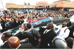  ?? — Reuters photo ?? People watch the procession of the hearse of Hussle as it passes in front of The Marathon Clothing store, on Wednesday.