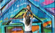  ?? COURTESY PHOTO ?? BELOW: Mike 360 holds his son Mixtli Chavarria, then 2, in front of a mural he painted in Richmond, Calif.